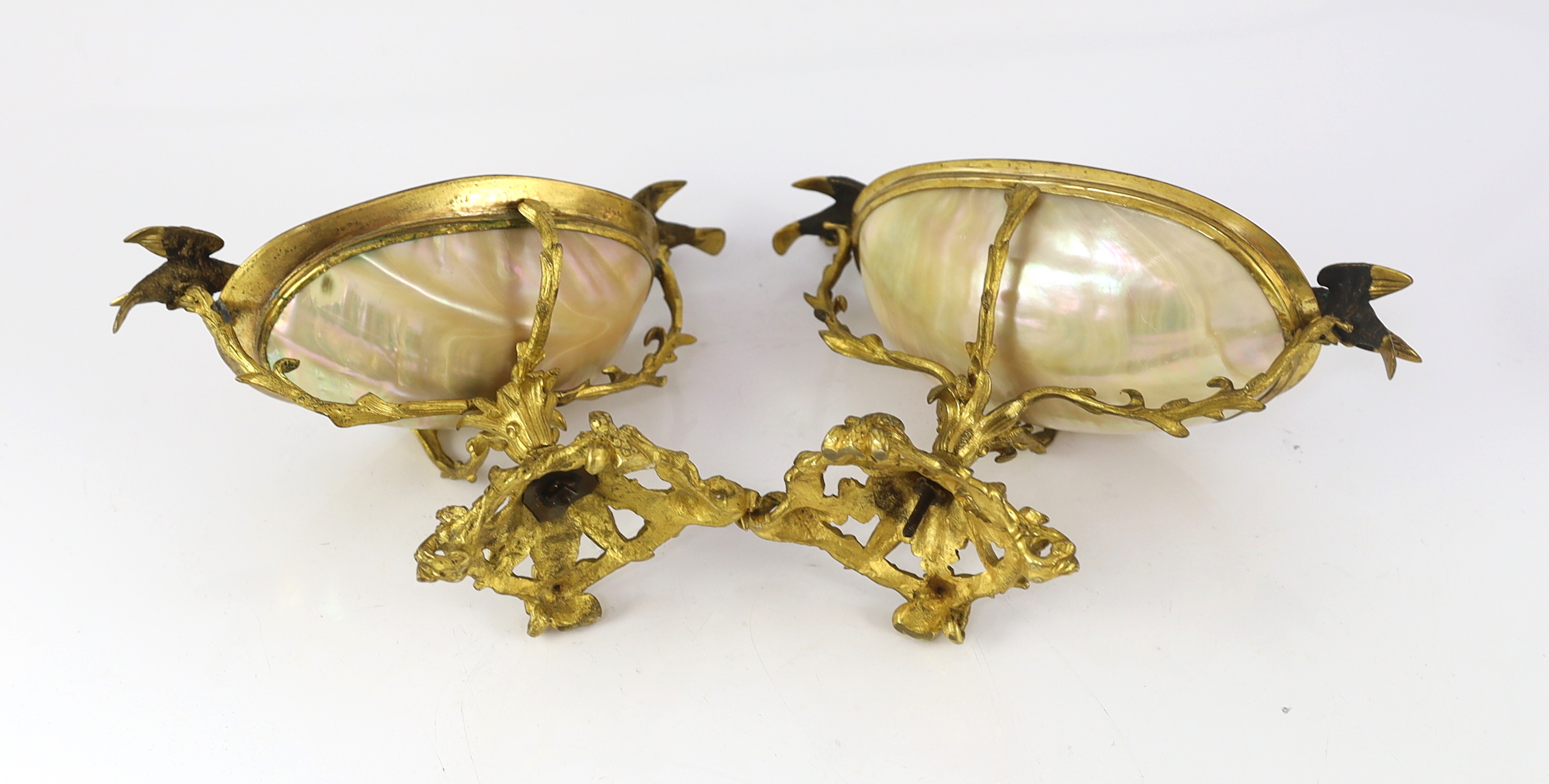 A graduated pair of 19th century Continental ormolu mounted mother of pearl pedestal bowls